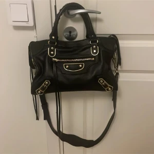 Balenciaga väska  - Balenciaga väska i svart och guld, nästan aldrig använd, defekter syns på slutet 
