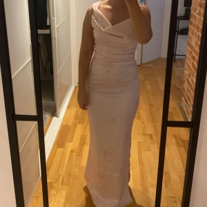 Ljusrosa långklänning Adoore - Super fin ljusrosa långklänning med en draperad halslinje/ vattenfall och smala axelband. Klänningen har en figurnära passform och är perfekt för speciella tillfällen. Klänningen är från Adoore och endast testad, finns prislappar och påse kvar! Nypris 1559kr