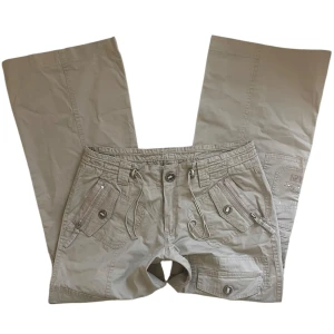 G.Cause cargobyxor  - Beiga lågmidjade utsvängda byxor med strassdetaljer och flera fickor 🤎Midjemått: 80 cm. Innerbenslängd: 66 cm. Grendjup: 22 cm. Ankelvidd: 26.5 cm. Jag brukar ha strl S i underdelar och är 1,67 för referens!