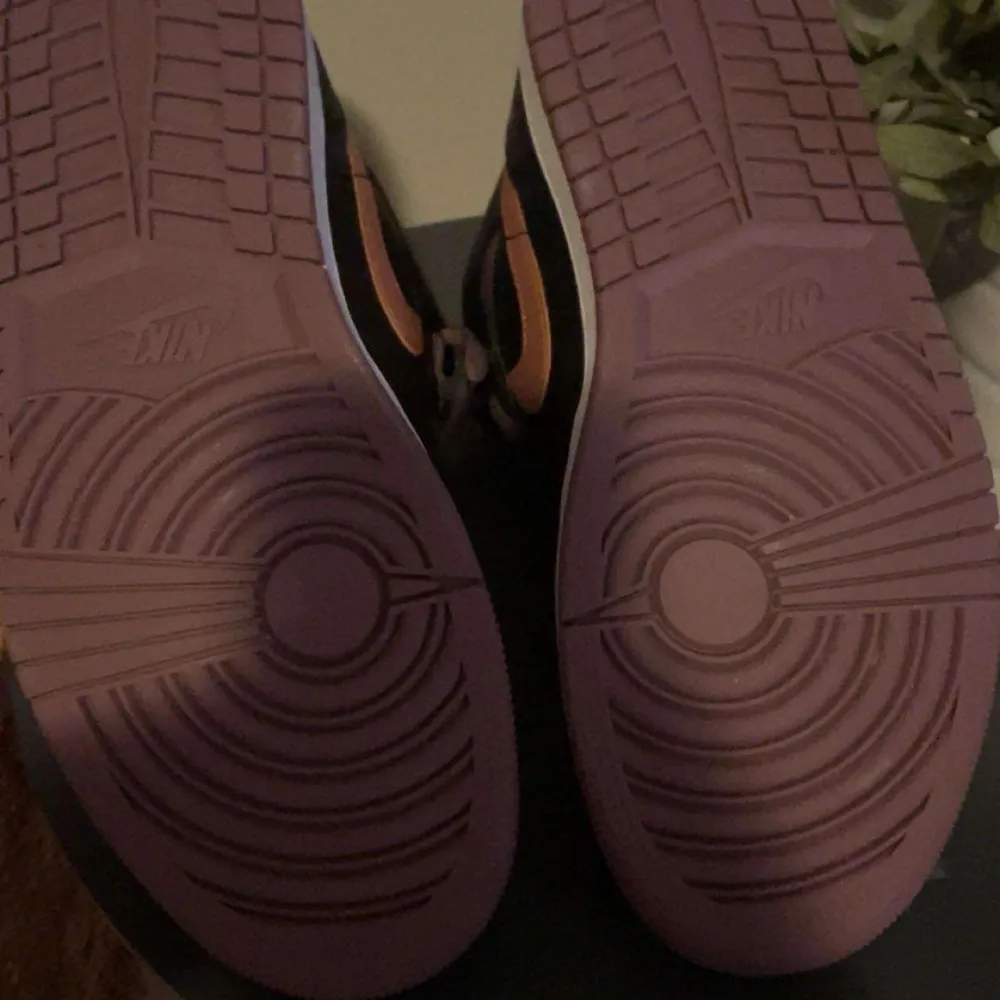Snygga Nike Air sneakers i svart och lila med orange detaljer. Skorna har en klassisk design med snörning och en bekväm sula. Perfekta för dig som vill ha en stilren look med en färgklick. Inga skador och använda cirka 3 gånger. Pris kan diskuteras!. Kengät.