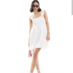 Vit klänning med volangdetaljer - Helt oanvänd klänning med prislapp kvar! Beställde den för att ha på studenten men hittade en annan klänning som jag använde istället! Stl xs men skulle säga att den passar a lika bra. Passar perfekt till student, midsommar eller liknande😇