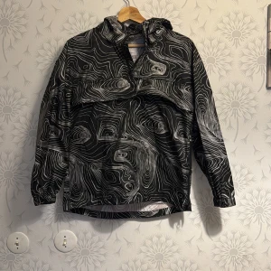 Svart och vit mönstrad jacka Luftig vattentät  - Snygg svart och vit jacka med unikt mönster. Jackan har en huva och långa ärmar, perfekt för en cool och avslappnad stil.ordinarige pris 599kr