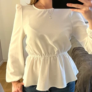 Vit blus med volangdetalj - Jättefin vit långärmad topp. Storleken är XS. Betalning sker via Swish och det är bara att höra av sig om ni undrar något🩵