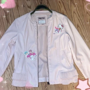 Ljusrosa jacka med hjärt-detaljer från Freestyle - Säljes på grund av att den blivit lite för liten 🫠  Den är storlek 15-16 (köpt i Spanien? Tror jag) men passar som en S! Jag har normalt sett M (170cm , 70kg ) och den går inte riktigt att stänga, men kan funka för någon med mindre byst❤️ Jackan har en dragkedja framtill och volangdetaljer vid midjan  Använd fåtal gånger med en liten defekt på bröstet! ( se bild )   ‼️Fake skinn‼️   coquette cute hello kitty emo alternativ. 