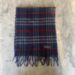 Mörkblå Burberry halsduk  - Skick: 8/10. Halsduken är i bra skick och har inga defekter. Mått: 146cm x 29cm 