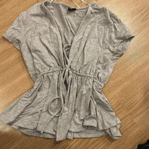 Grå omlottopp med knytband - Topp storlek S från bikbok aldrig använd. Säljer  då den inte kommer till användning 💗