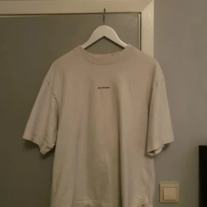 Vit t-shirt från Acne Studios - Säljer en stilren vit t-shirt från Acne Studios. Den har en klassisk rund hals och korta längre armar! Billigare vid snabb betalning o swish!!