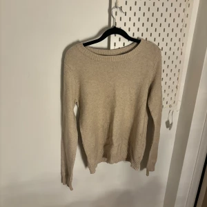 Beige stickad tröja  - Säljer en stilren beige stickad tröja från vila. Tröjan har en klassisk rund hals och långa ärmar med ribbade muddar. Perfekt för kyligare dagar och enkel att matcha med olika outfits.