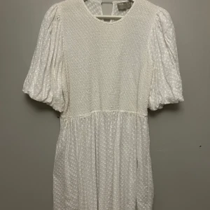 Vit klänning med puffärmar - Vit klänning med puffiga kortärmar och ett diskret prickigt mönster. Klänningen har en rund halsringning och en luftig passform. Endast använd 1 gång🫶🏼 superfin till student eller konfirmation 💗