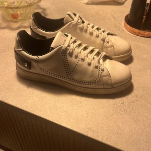 Vita valentino backtab - Snygga vita sneakers från Valentino Garavani med perforerade detaljer. Skick 7/10. Köpta på Natalie Schutterman. Storlek 41 1/2 men passar 42/43 (OBS kan tänka mig byte samt byte + pengar)