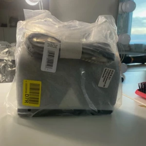 Svart handväska från Aldo - Snygg svart handväska från Aldo, perfekt för att komplettera din outfit. Väskan har en stilren design och är förpackad i plast. Den är kompakt och lätt att bära med sig. Helt ny och kostar nu 396 på Zarlando!