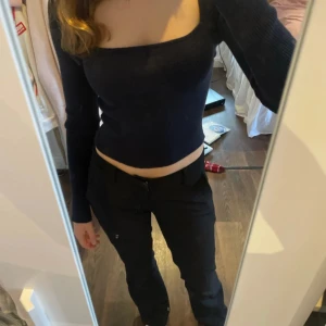 Marinblå stickad tröja - Snygg svart ribbad topp med lång ärm och croppad passform. Perfekt för en stilren look. Aldrig använd