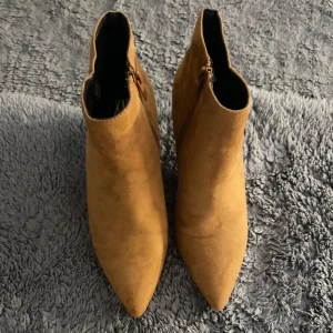 Senapsbruna mocka boots med dragkedja - Snygga bruna boots i mocka med spetsig tå och dragkedja på sidan. Perfekta för höst och vår med en stilren design som passar till många outfits. Knappt använda.❤️