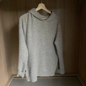 Kashmir hoddie  - Mysig grå Kashmir  med långa ärmar och en klassisk huva. Perfekt för kyliga dagar och avslappnade stunder. Enkel och stilren design som passar till det mesta.