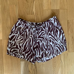  Shorts - Snygga shorts i brunvitt zebramönster med knytband i midjan. Lätta och bekväma att bära. Storlek S. 