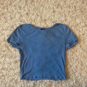 Blå t-shirt  - Jättefin blå tajt och ribbad T-shirt ifrån Gina tricot, tröjan är använd, men har inga defekter. Pris kan diskuteras och jag kan skicka fler bilder😊