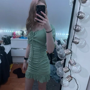 Grön klänning från Shein - Snygg grön klänning från Shein med kort längd och volangdetaljer. Klänningen har en åtsittande passform och korta ärmar. Perfekt för en somrig look! 💚