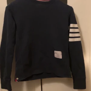 Thom Browne tröja - Säljer denna fina Thor Browne tröja ifrån 2014 då den är för liten på mig.                               Storleken är 0 som motsvarar S men skulle vilja säga att den passar folk som bör XS. Är 175 och den är för liten så ni får avgöra resten själva. Inget OG tillkommer därav priset!
