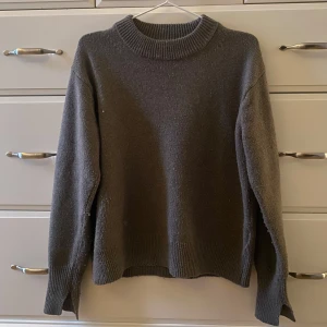 Grå/ brun stickad tröja - Säljer en mysig grå stickad tröja. Perfekt för kyliga dagar och enkel att matcha med olika outfits. Tröjan har en klassisk design som passar till många tillfällen.