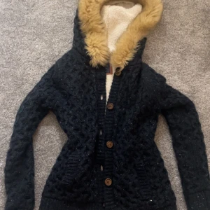 Svart stickad jacka från Bershka - Mysig svart stickad jacka från Bershka med en fluffig fuskpälsfodrad huva 💕💕 y2k 2000s hoodie med päls köpt här på plick!