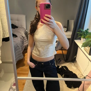 Glansig topp - Jättesöt topp i lite vit/beige färg. Inte så använd så väldigt bra skick.