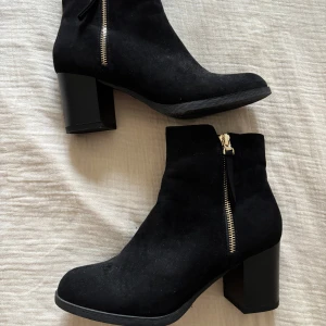 Svarta boots med dragkedja - Snygga svarta boots från XIT med dragkedja på sidan. De har en robust klack och är tillverkade i mocka. Perfekta för en stilren look.