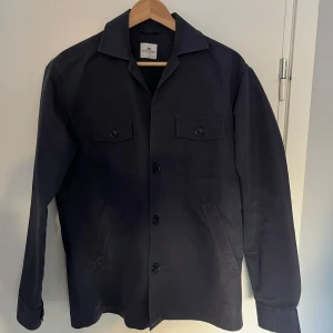 Marinblå overshirt från John Henric - Säljer en marinblå overshirt från John Henric i storlek S. Har använts varsamt och har inga defekter över huvudtaget. 