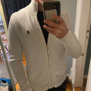Ralph lauren stickad tröja - Säljer en sällsynt vit stickad tröja som inte längre säljs från Ralph Lauren i mycket fint skick! Tröjan har långa ärmar med ribbade detaljer och är perfekt för både höst och vinter. Priset kan diskuteras!