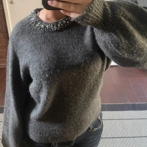 Grå stickad tröja från ONLY - Säljer en superfin grå stickad tröja från ONLY, dekorerad med glittriga pärlor runt halsen. Pris kan diskuteras 🙃