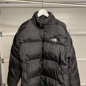 Svart pufferjacka från The North Face - Säljer en svart pufferjacka från The North Face i  bra skick . Jackan är perfekt för kalla vinterdagar och har en dragkedja framtill. Den är långärmad och har en normal passform. Supermysig och varm! Säljes i befintligt skick. Storlek XL/L