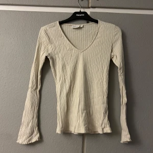 Beige ribbad tröja från KappAhl - Säljer en snygg beige ribbad tröja från KappAhl i storlek S. Den har en v-ringad hals och långa ärmar, perfekt för både vardag och lite finare tillfällen. Tröjan är i bra skick och passar perfekt till höst- och vårgarderoben. Skicka ett meddelande vid intresse!
