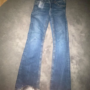 Blå jeans från Gina Tricot - Säljer ett par snygga blå jeans från Gina Tricot i storlek 158,dom är lågmidjade och bootcut. De har en klassisk femficksdesign och är i bra skick. Perfekta för vardagsbruk med en bekväm passform. Passar både till skolan och fritiden! (dom fick hål i sig men vi sydde dom och dom funkar som dom ska!)