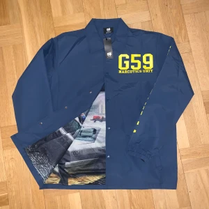 G59 Narcotics Jacka - Oanvänd G59 Records/$uicideboy$ jacka i XXL. Fick den i min mystery box 2023 men den är inte min stil.  Cool detalj med The Dark Glacier Saga cover art på insidan. Skicka gärna prisförslag!