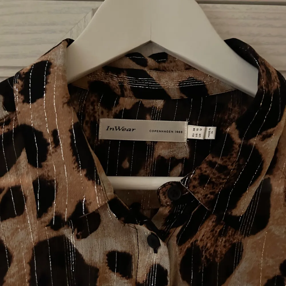 Säljer en supercool leopardmönstrad blus från InWear. Den har långa ärmar och knappar framtill. Perfekt för att sticka ut på festen eller bara för en vanlig dag när du vill känna dig extra snygg. Materialet känns lyxigt och mönstret är riktigt trendigt. 🐆✨. Blusar.