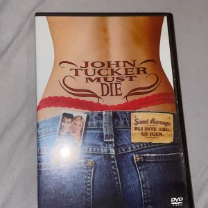 John Tucker Must Die - DVD-film med titeln 'John Tucker Must Die'. Omslaget visar en person i jeans och röd spets, med titeln i stora bokstäver. Baksidan beskriver handlingen där skolans tjejer planerar hämnd på John Tucker. Innehåller extramaterial som borttagna scener och musikvideo. Perfekt för en filmkväll med komedi och drama!