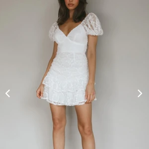 Vit spetsklänning med puffärmar - Hejsan! Säljer nu min studentklänning som endast är använd en gång, så super bra skick! det är en vit spetsklänning med v-ringning och kort längd. känningen har puffiga kortärmar och en omlott-design framtill. samt dekorerad med volanger och har en knytning i ryggen. vet inte om den fortfarande säljs, men den var väldigt eftertraktad i våras. klänningen inklusive frakt + tull kostade mig ca 1800kr, så därför säljer jag för 900kr. pris går att diskutera, så bara att höra av er vid frågor!💓