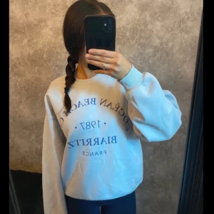 Ljusblå sweatshirt med tryck - Säljer en ljusblå sweatshirt med tryck framtill. Tröjan har en avslappnad passform och långa ärmar, perfekt för en casual look. Den är mjuk och bekväm, idealisk för kyligare dagar.