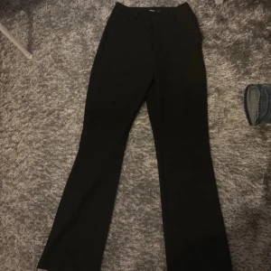 Svarta kostymbyxor - Snygga svarta kostymbyxor med hög midja och bootcut-stil. Perfekta för fest men även vanliga dagar. 