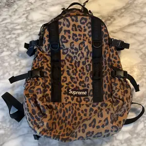 Säljer en cool leopardmönstrad ryggsäck från Supreme. Den är vattentät, har flera justerbara remmar och en stor dragkedja för enkel åtkomst. Perfekt för både skola och fritid. Ryggsäcken är i mycket bra skick och redo för nya äventyr! 🐆