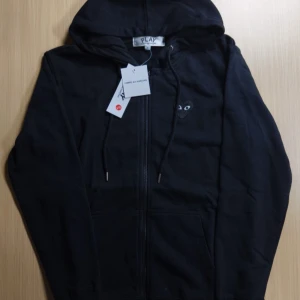 Svart hoodie med dragkedja från PLAY - Ångrade mitt köp i efterhand men går inte att skicka tillbaka då jag inte har öppet köp på den. Helt ny med lappar bara provad på. Därav det billiga priset som inte är hugget i sten 🪨 