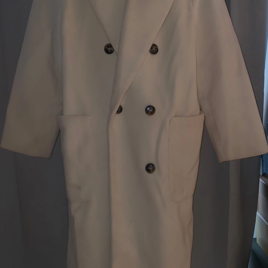 Beige kappa med knappar