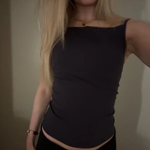 Svart ärmlös topp - Snygg svart ärmlös topp i tight passform. Perfekt för både vardag och fest. Enkel och stilren design som passar till det mesta. Toppen är bekväm och supersnygg💕