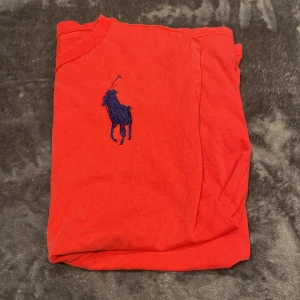 Ralph Lauren t-shirt röd - Säljer min sköna Ralph Lauren T-shirt röd som är i riktigt bra skick. Inga som helst skador eller liknande;) den är då i storlek 14-16 yrs = S. Sitter på mig som är 173 cm & 63 kg bra;) Givetvis äkta✅ Hör av dig vid frågor eller funderingar. Mvh Oliver! 