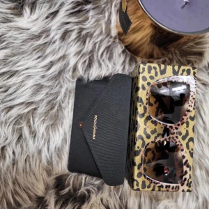 Leopardmönstrade solglasögon från Dolce & Gabbana - Snygga solglasögon från Dolce & Gabbana med leopardmönster. De har en trendig design med breda skalmar och mörka linser. Perfekta för att ge din stil en extra edge. Storlek 54...De är självklart äkta...inga repor inga defekter...