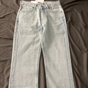 Ljusblå jeans från Never Denim - Säljer ett par ljusblå jeans från Never Denim i modellen JP Low Straight 510. De har en klassisk femficksdesign och är lågmidjade med en rak passform. Perfekta för en avslappnad stil.