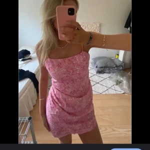 Rosa blommig klänning från Zara - Säljer en söt rosa klänning från Zara med blommigt mönster. Klänningen är kort och har smala axelband. Perfekt nu till sommaren🩷klänning är använd endast en gång så i mycket bra skick (första bilden är lånad)