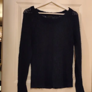 Mörkblå stickad tröja från Vero Moda - Säljer en snygg mörkblå stickad tröja från Vero Moda. Tröjan har en luftig stickning och långa ärmar, perfekt för kyliga dagar. Den är både stilren och bekväm, ett måste i garderoben!