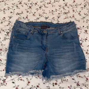 Blå jeansshorts från Blue Motion - Säljer ett par snygga blå jeansshorts från Blue Motion i storlek 40. De har en klassisk femficksdesign och fransiga kanter för en avslappnad look. Perfekta för sommardagar och festivaler! 🕶️
