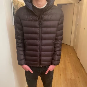 Colmar dunjacka (mörkbrun) - Mörkbrun colmar jacka. Perfekt till kalla höstdagar men även till vintern. Skick 9/10 inprenicip som helt ny fast utan prislappen. Nypris 4800kr. Eu storlek 46 som sitter som ungefär s. Personen på bilden är 183 cmungefär. Skriv vid frågor. (Kan även passa tjejer)