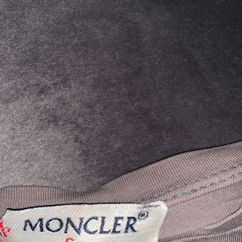 Snygg beige t-shirt från Moncler med stort broderat Moncler-logotyp på bröstet. Tillverkad i bomull och lycra för en bekväm passform. Perfekt för en avslappnad stil.. T-shirts.